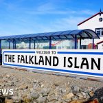 Diplomats discussing Falklands claims memo in a formal setting.