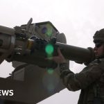 Military personnel discuss strategies at a base amid ongoing attacks in Iraq.