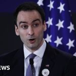 Business professionals discussing AI technology theft concerns in an office.