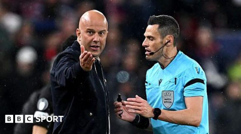 Football officials discussing VAR decisions during a Liverpool match.