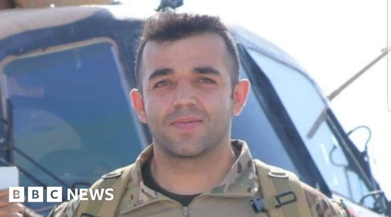 A diverse group aiding an Afghan veteran collapse at a railway station.