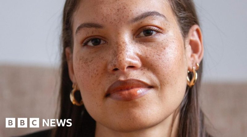 A young woman confidently speaking Welsh in a diverse group conversation.
