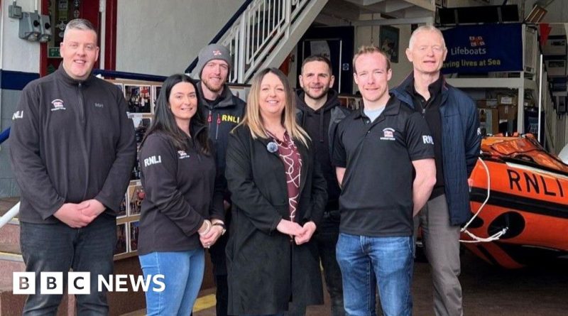 Lifeboat crew member demonstrates a lifeboat crew rescue in action.