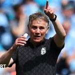 Wrexham football players preparing for a match to secure a play-off spot.