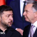 Diplomats discussing US envoy visits to Kyiv in a formal office setting.