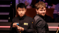 Zhao Xintong celebrates victory in an emotional snooker match.
