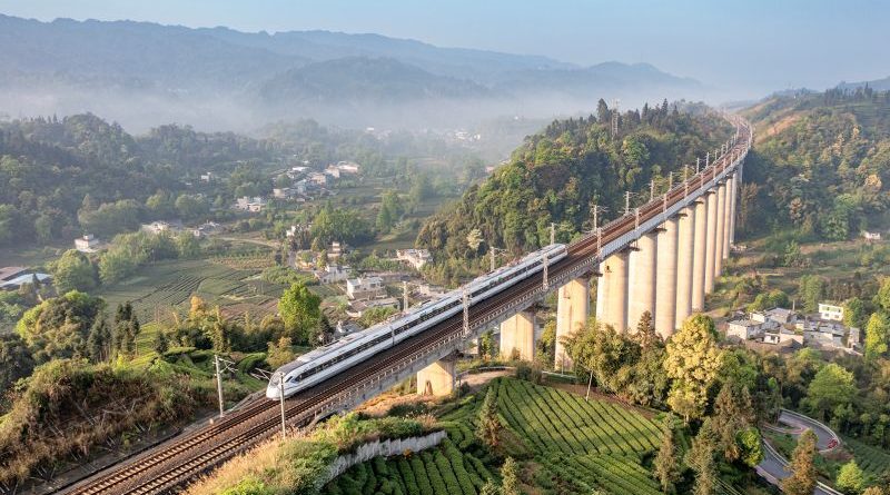 Professionals discussing high-speed trains in a modern office setting.