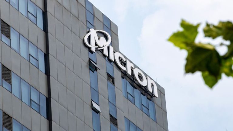 Business professionals discussing Micron Technology cybersecurity investigation in a modern office setting.