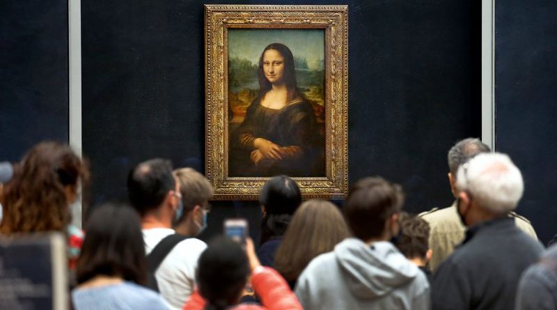 Art historians and scientists studying da vinci paintings technique in a lab.