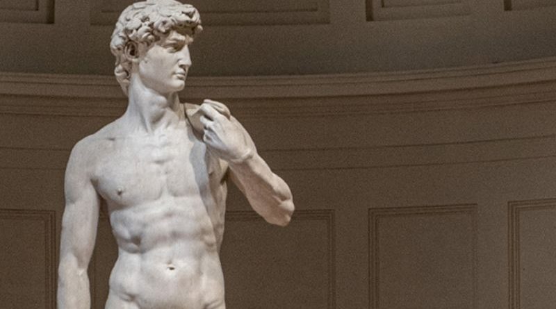 Visitors admire Michelangelo's David sculpture in a respectful museum setting.