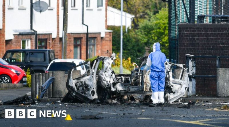 Police officers discussing security measures after the Dunmurry police station explosion.