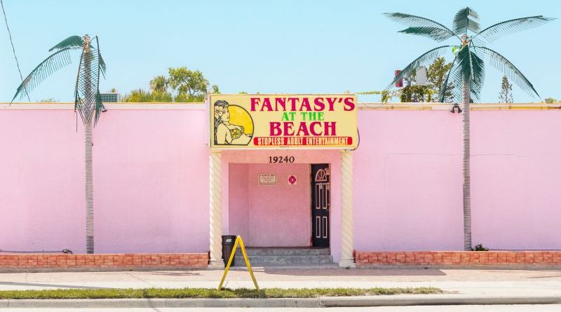 Exterior of American strip clubs showcasing unique designs and neon lights.