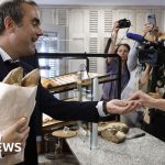 A lively bakery scene representing the French Prime Minister bakery visit.