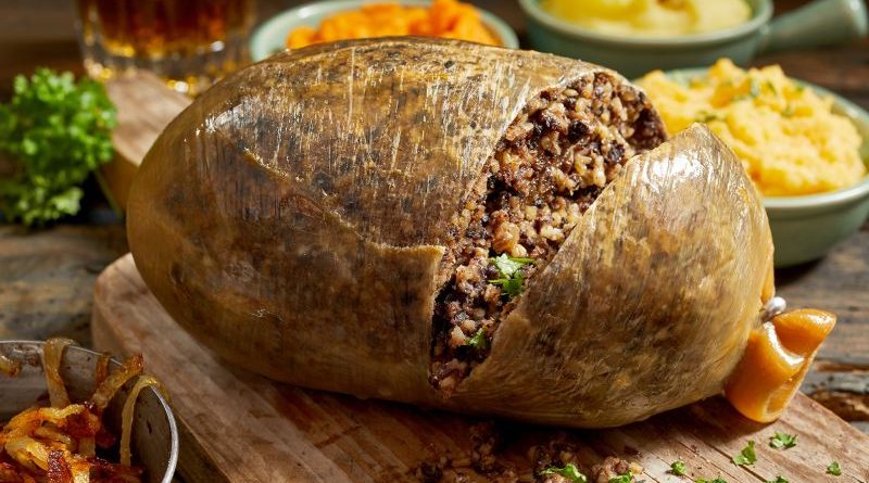 A table with people enjoying Scottish haggis in a formal dining setting.