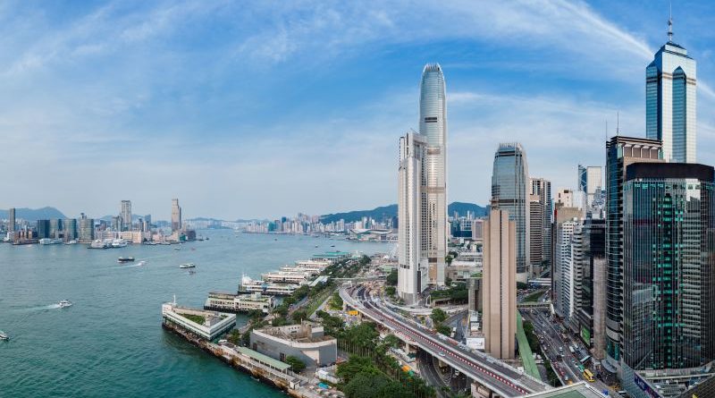 A diverse group of tourists in professional attire enjoying the sights of Hong Kong.