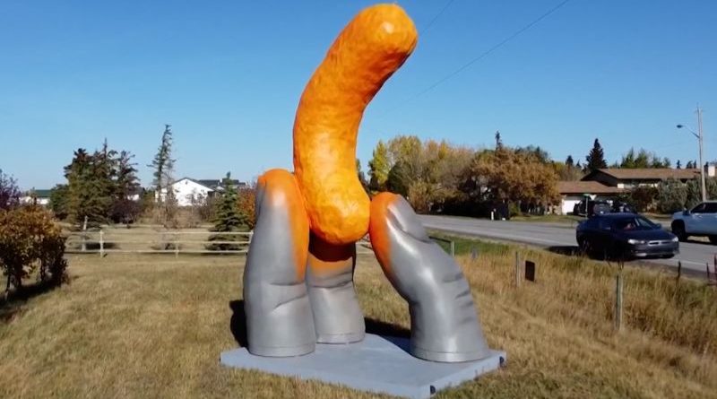A crowd of people enjoying the giant Cheeto roadside attraction.