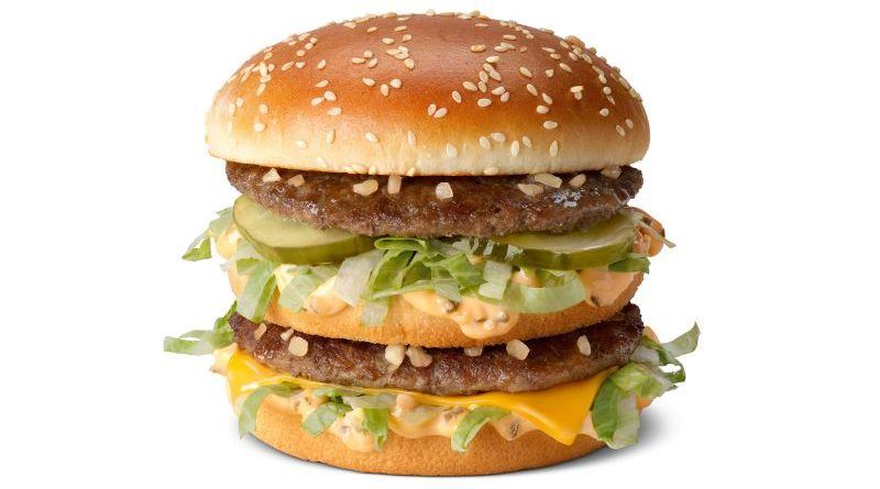 Employees preparing McDonald's burger upgrades with fresh ingredients.