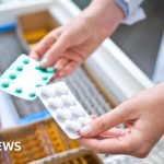 Healthcare professionals discussing medication access issues in a pharmacy.