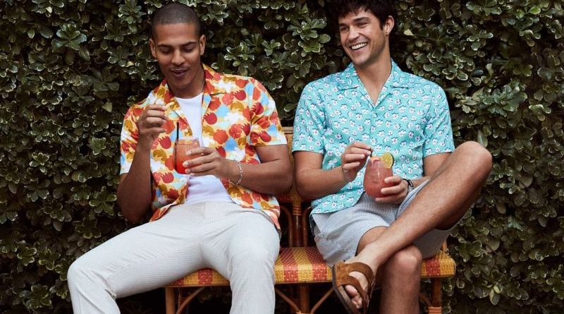 Men in stylish spring fashion outfits enjoying a casual outdoor gathering.