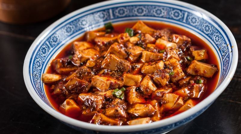 A lively street market scene featuring must-try Chinese dishes.