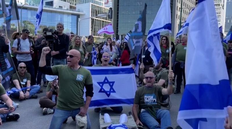 Israeli military veterans protesting for change, holding flags in solidarity.