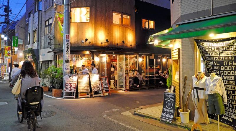 A lively urban neighborhood scene showcasing the world's coolest neighborhood with diverse people enjoying outdoor spaces.